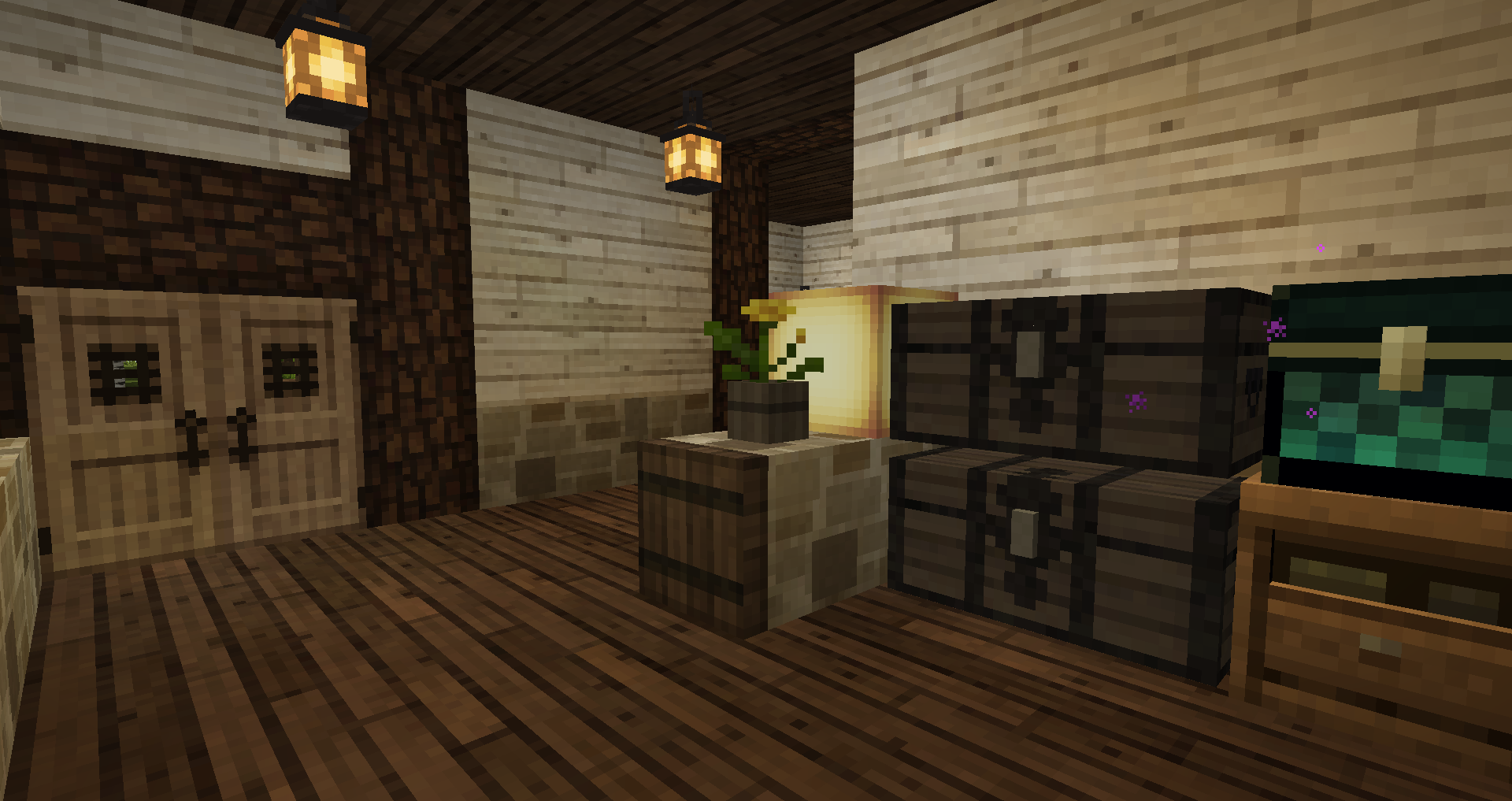 Screenshot of the inside of a house in Minecraft. It's not too small and not too big, built in mostly wood and warmly lit with lanterns. There are two double chests, one Ender chest and one crafting table neatly stacked in the right side corner, next to a granite divider with a dandelion in a pot and yellow froglight on it. On the far wall from the viewer is a set of double doors leading outside. There is space deeper in the house that isn't visible from this angle.